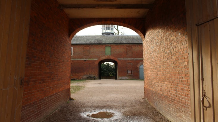 Looking through the archway into the Stableyard at Calke Abbey, Derbyshire